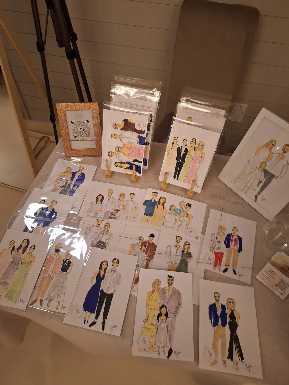 Mesa da ilustração ao vivo com os retratos dos convidados expostos, prontos a levar