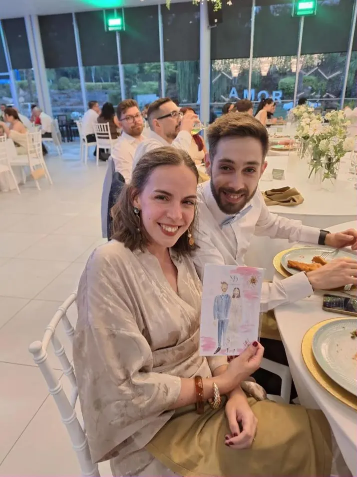 Casal de convidados sentado à mesa a mostrar a sua ilustração