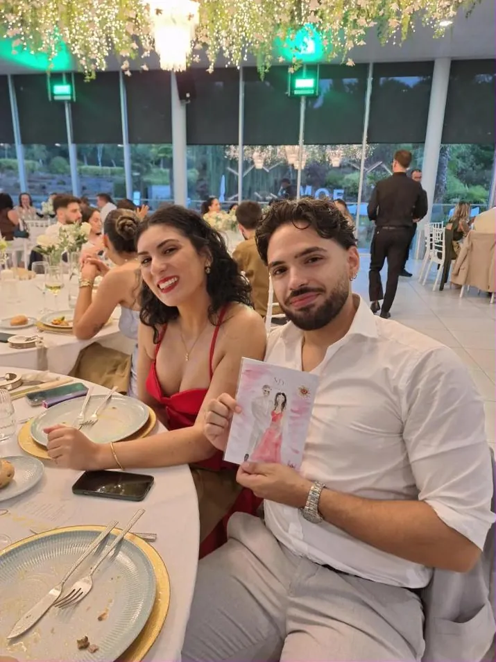 Convidada de vestido vermelho e o seu par com o retrato acabado de receber